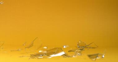 Glass shards from a glass lie on a plain bright background video