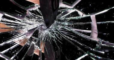 Slow motion of a hammer hitting a mirror, a lot of cracks and debris appear after being hit video
