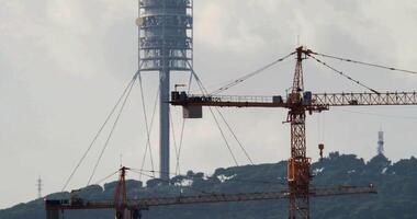 A tower crane is seen in front of a tower video