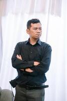 Contemplative man with arms crossed, exuding a sense of skepticism photo