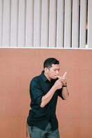 Contemplative man lighting cigarette against modern architectural backdrop photo