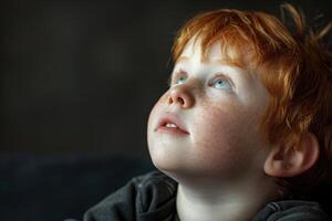 portrait of redhead child boy with freckles on face on black background photo