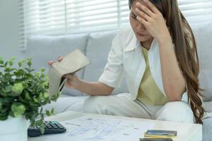 Stressed and headache asian woman with large bills or invoices no money to pay to expenses and credit card debt. shortage, Financial problems, mortgage, loan, bankruptcy, bankrupt, poor photo