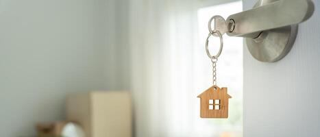 relocation. The key was inserted into the door of the new house, inside the room was a cardboard box containing personal belongings and furniture. move in the apartment, banner photo