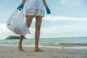 Save water. Volunteer pick up trash garbage at the beach and plastic bottles are difficult decompose prevent harm aquatic life. Earth, Environment, Greening planet, reduce global warming photo