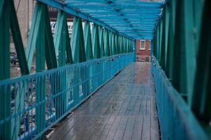 A bridge with blue metal railings and a walkway photo