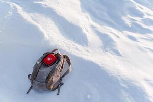 A backpack is sitting on top of a snow covered hill photo