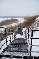 A set of stairs leading up to a snowy hill photo