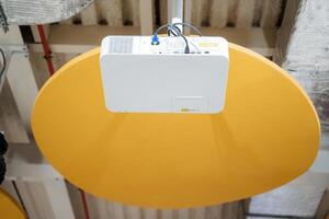 A yellow circular object with a white wire attached to it photo