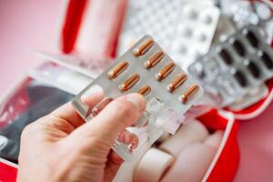A person has a blister pack of pills held securely in their hand, clearly showing the small compartments that generally contain the medication that is packaged within it safely photo