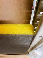 A vibrant, eyecatching yellow foam rests gently on a robust and sturdy metal piece, creating a captivating and fascinating contrast between the two distinct and unique materials photo