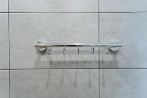 A towel rack is securely hanging on a beautifully tiled wall, adding both functionality and style to the space. It complements the overall aesthetic of the tiled interior design photo