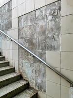 This piece features a textured wall accompanied by a staircase, showcasing the themes of urban decay and the subsequent repair process involved in revitalizing the space photo