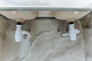 The bathroom features a welldesigned sink with two strategically placed drains underneath, improving drainage efficiency and offering versatility for different plumbing needs photo