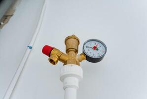 This is a detailed closeup view of a valve featuring a pressure gauge that is securely attached to it, allowing for precise measurement of pressure in a plumbing system or machine photo