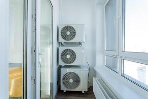 On a spacious balcony, there are two air conditioners that are neatly stacked one directly on top of the other. They prominently enhance the utility and overall functionality of the space photo
