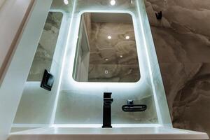 The modern bathroom features a stylish sink, wellplaced mirror, and chic faucet, enhancing convenience and functionality, creating a harmonious atmosphere for daily routines photo