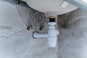 This is a sink that has a drain pipe securely attached to it, which ensures that water can flow properly away from the sink after it has been used for various activities photo