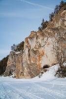 In a snowy mountain landscape, a large cave uniquely nestles amid the icy expanse, creating a stunning contrast against the pristine white scenery, making it truly remarkable to observe photo
