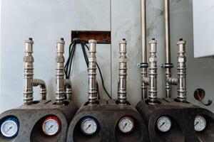 In a spacious industrial room, a wellorganized row of pipes, gauges, and equipment showcases remarkable functionality and operational precision, demonstrating efficiency photo