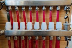 In this image, we can see a closeup view of a heating system that features distinct red pipes along with white caps, showcasing the intricate design and components involved photo