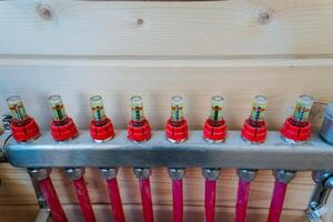 This image offers a closeup of an efficient heating system, featuring vivid red pipes and caps that illustrate its intricate design and functionality for optimal heating performance photo