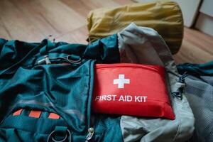 A first aid kit is positioned securely on top of a sleeping bag, ready for use whenever needed, ensuring safety and preparedness during outdoor adventures or camping trips photo