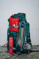 A sturdy backpack that comes equipped with a first aid kit and an insulated thermos attached to it, making it ideal for outdoor adventures and everyday carry necessities photo