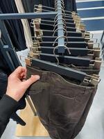 A fashionable person displays stylish brown pants made from premium fabric with intricate texture, suitable for various occasions and appealing to diverse fashion tastes photo