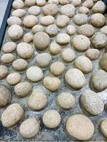 A collection of various rocks is stacked upon one another on a sturdy table, creating an interesting display that draws attention and curiosity from anyone who happens to see it photo