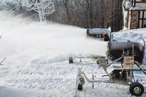 In a picturesque snowy area, a large machine efficiently blows snow, creating an enchanting flurry of sparkling white flakes, beautifully painting a stunning picture of a winter wonderland photo