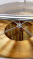 Automatic honey extracting machine rotating many frames at once. Barrel-like apparatus removing honey from honeycombs. Top view. Vertical video