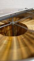 Working machine for honey extracting from wooden frames with honeycombs. Metal barrel with centrifuge mechanism spinning quickly the frames. Top view close up. Vertical video