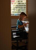 View of a boy doing homework at his desk photo