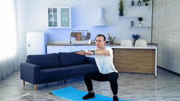 Sportman doing exercise at home. Man doing squats and exercising in living room at home video