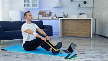 Man doing exercise with online tutorial. Attractive young man doing exercising at home video