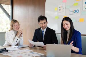 Engaged diverse business team discussing financial reports and strategies in a modern office setting. photo