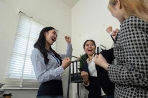 Diverse business team celebrating success in an office, expressing joy and teamwork. photo