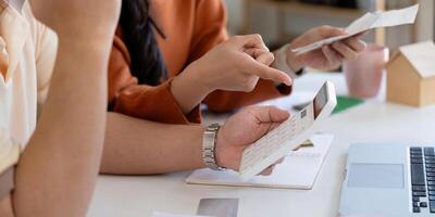 Couple discussing financial planning and managing bills with calculator and documents. photo