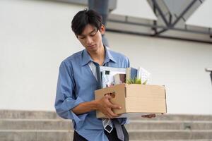 Professional man exiting workplace with a box of belongings, indicating a significant career shift. photo