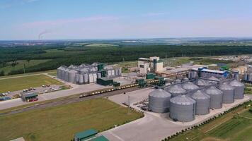 Enormous plant for storing and processing grain. Modern complex of grain elevators for keeping and drying crop. Drone view. Beautiful nature scenery at the background. video