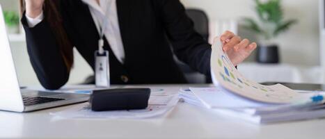 Financial analyst reviewing tax documents and calculations at a desk with a calculator and reports. photo