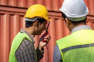 Construction engineers discussing logistics and plans on-site with communication devices. photo