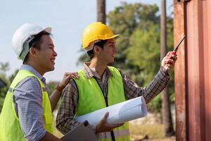 Engineers collaborating on construction plans outdoors with blueprints and communication devices. photo