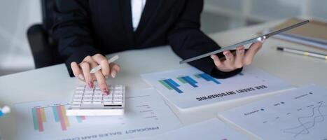 Accountant managing financial calculations with a calculator and tablet for insights photo