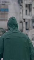 Stalker survivor after nuclear chemical war. Man in protective uniform and gas mask in destroyed place. Man-made disaster. Post apocalyptic world. Back view. Vertical video