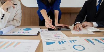 Business team analyzing budget pie chart and data reports during a meeting, discussing financial performance and strategies. photo