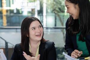 Engaged female colleagues collaborating on project analysis and strategic planning in a contemporary office. photo