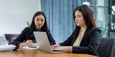 Diverse female team members brainstorming project ideas and analyzing strategies in a bright office environment. photo