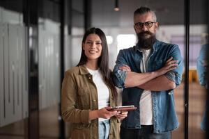 Creative millennials, casual business team, small business owners, working on social media strategy and brand development with a digital tablet in a modern, open space startup office photo